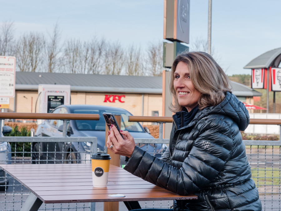 Woman waiting for car to charge